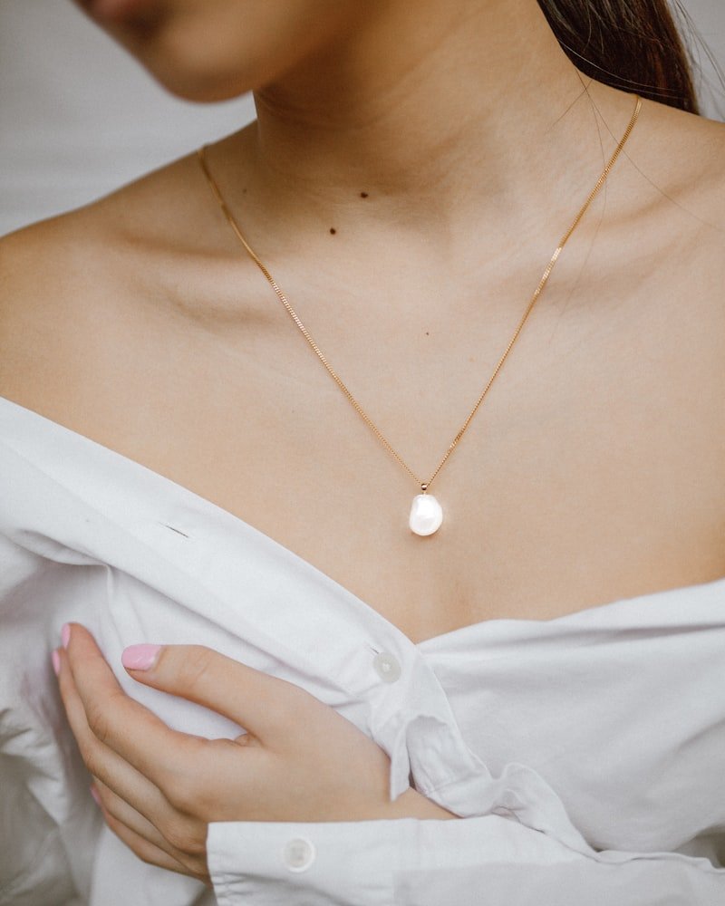 Fine gold-tone chain necklace with a single freshwater pearl pendant